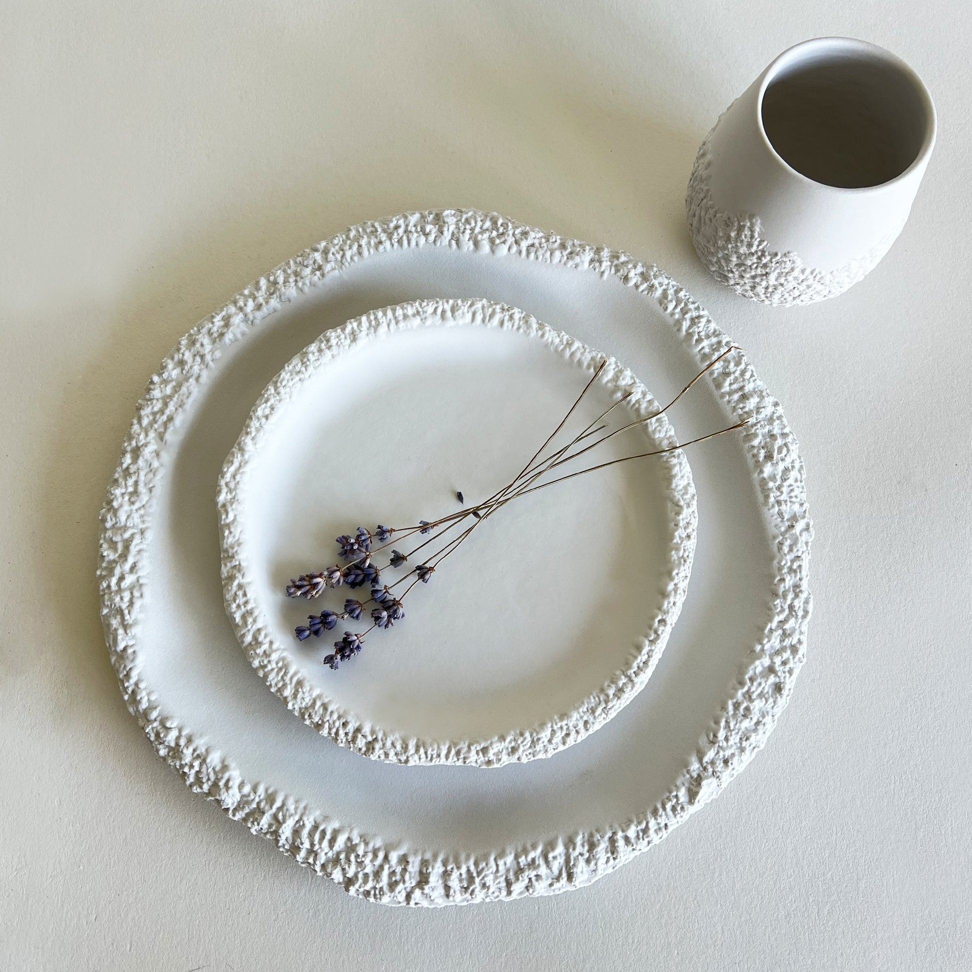 white textured ceramic plates and cup