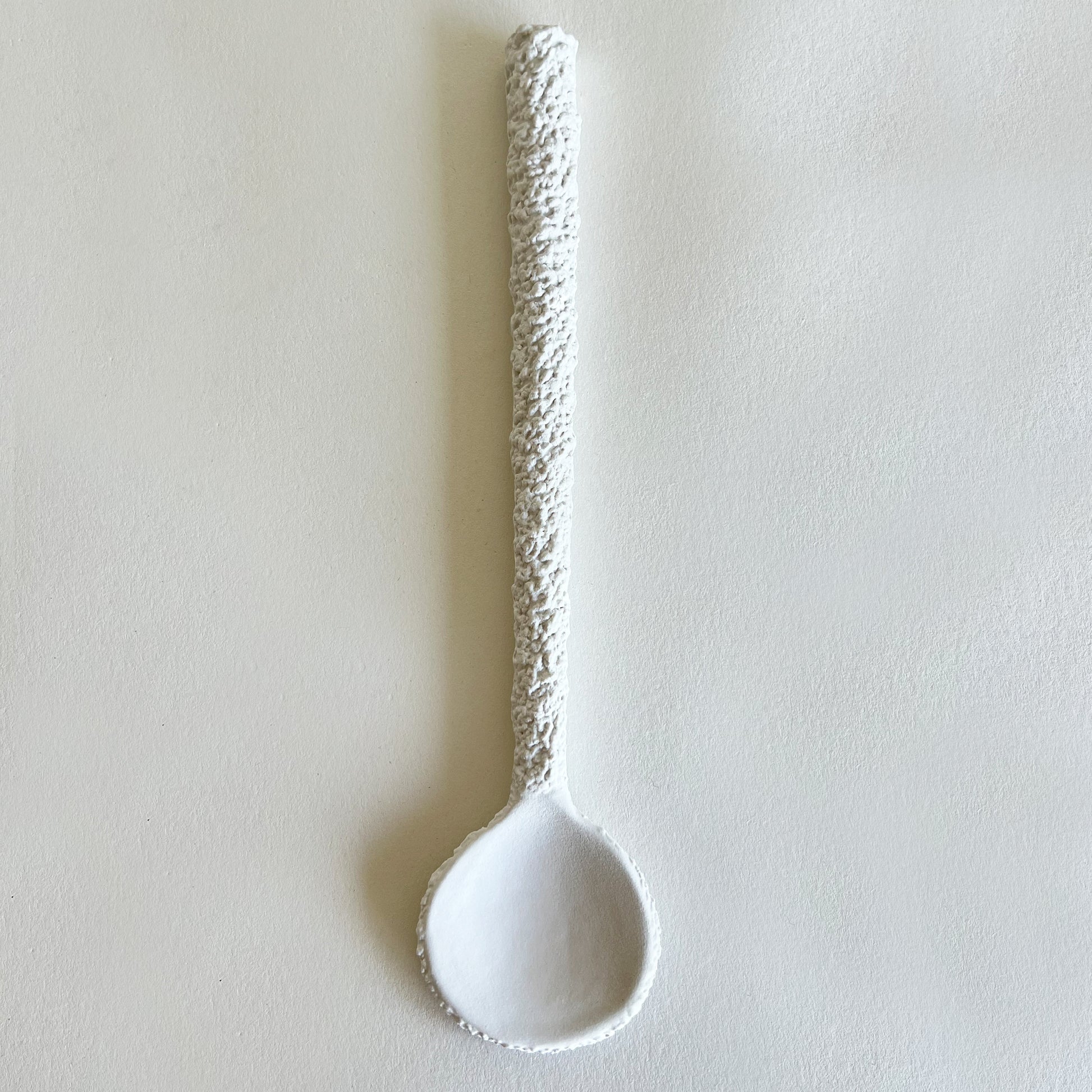 white ceramic textured serving spoon 